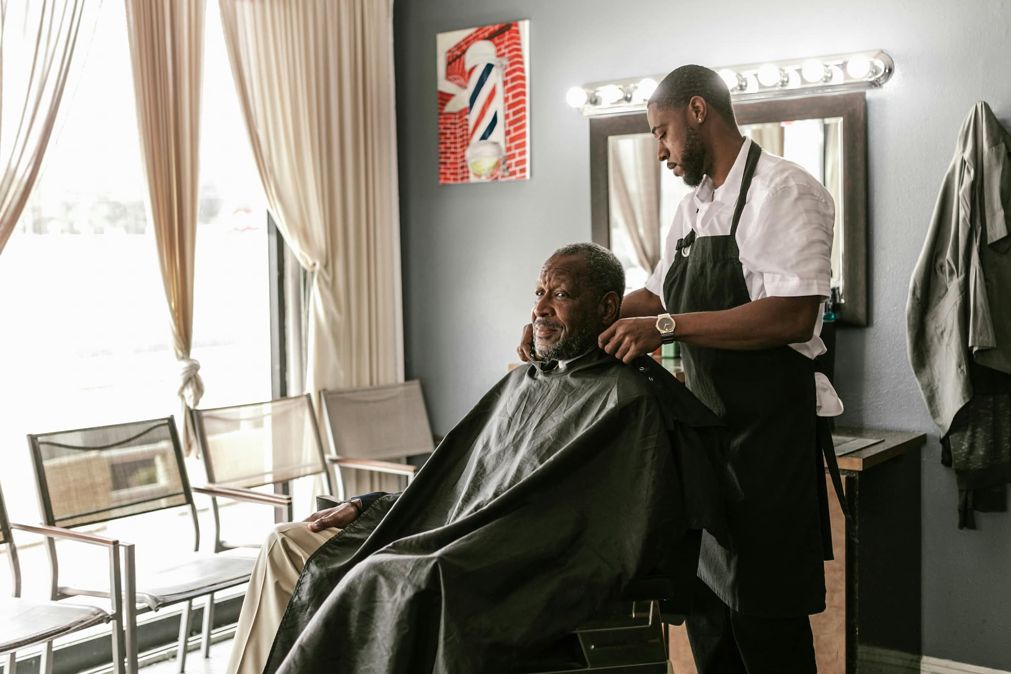 a barber wearing a client an apron