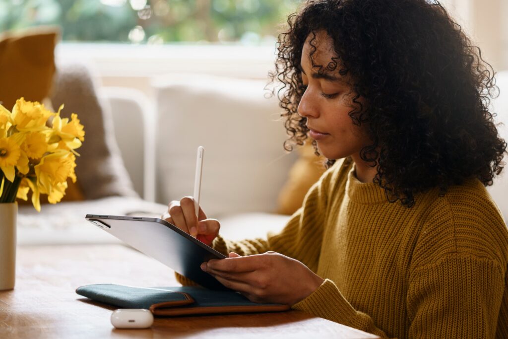A woman using her tablet to write.