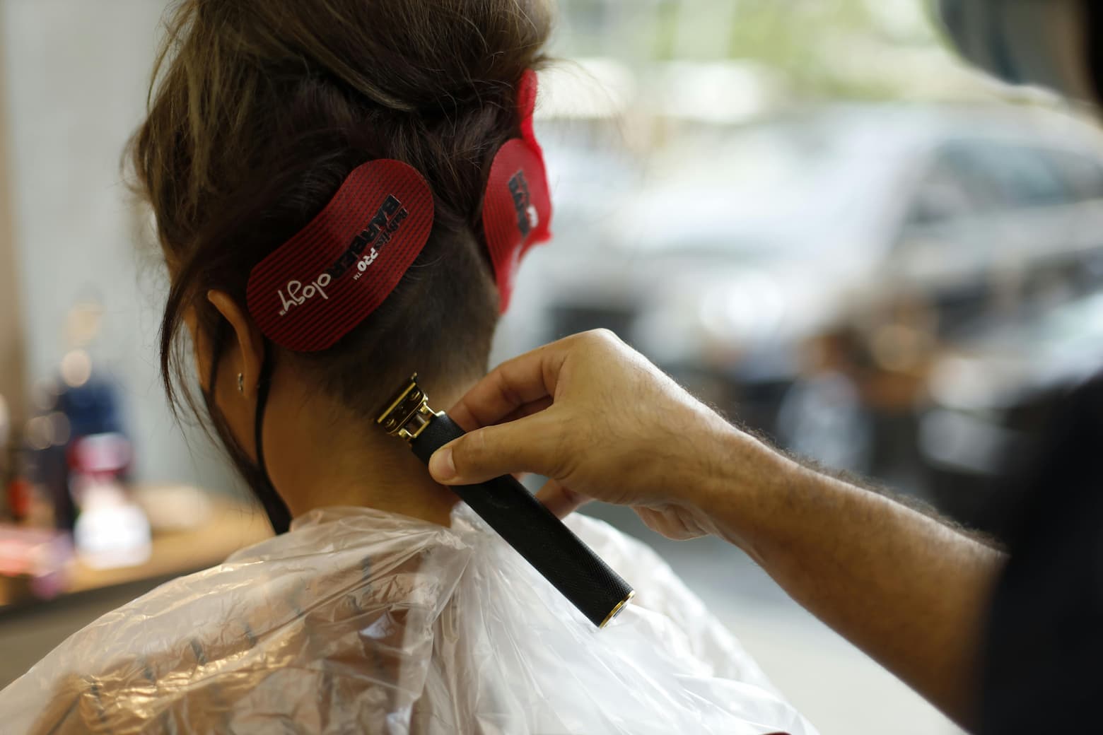 A barber cutting a woman's hair,