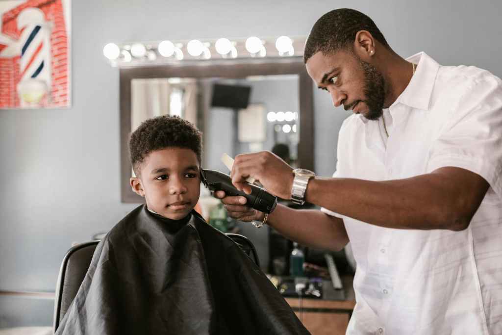 a barber cutting a young boy's hair